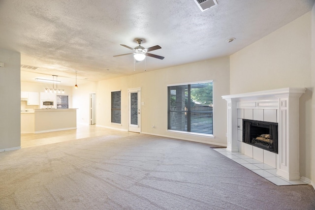 803 Sterling Ct, Allen, TX 75002 - unfurnished living room with light carpet, ceiling fan, a tile fireplace, a textured ceiling, and baseboards