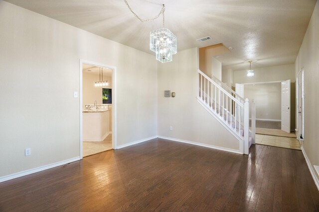 803 Sterling Ct, Allen, TX 75002 - unfurnished living room featuring a chandelier, hardwood / wood-style flooring, stairs, and baseboards