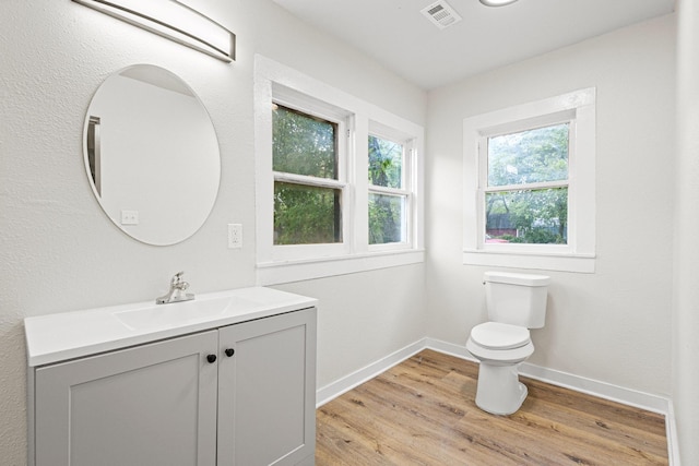 1031 W Chestnut St, Denison, TX 75020 - bathroom featuring toilet, vanity, wood finished floors, and baseboards