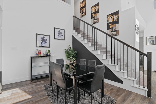 3023 Wind Knot Way, Royse City, TX 75189 - dining space featuring a towering ceiling, wood finished floors, stairs, and baseboards