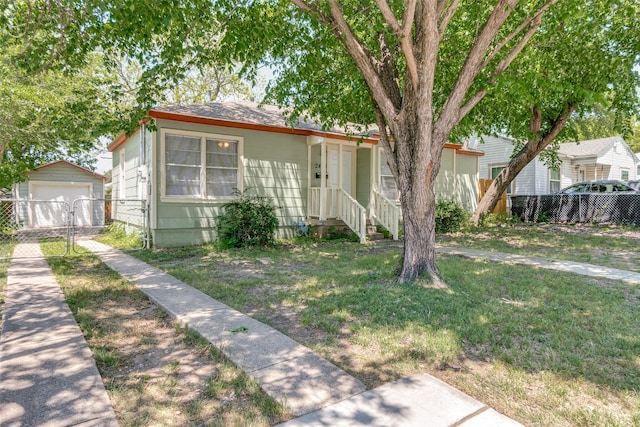view of front of home with a detached garage, driveway, an outbuilding, and fence