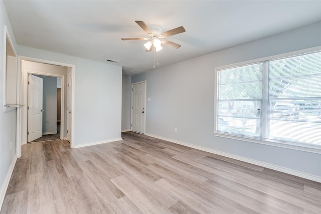 unfurnished room featuring ceiling fan, baseboards, light wood-style floors, and visible vents