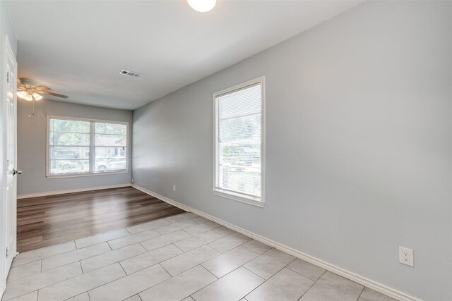 empty room with visible vents, a ceiling fan, baseboards, and light tile patterned floors