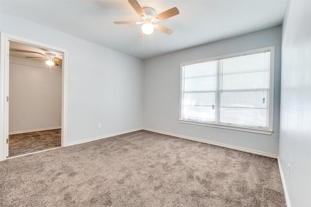 unfurnished bedroom with carpet, a spacious closet, and baseboards