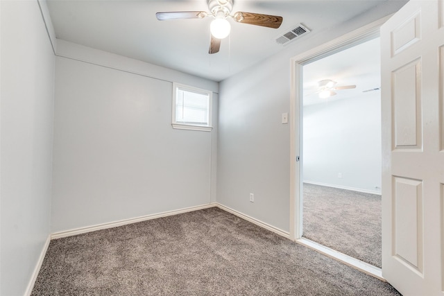carpeted empty room featuring baseboards, a ceiling fan, and visible vents