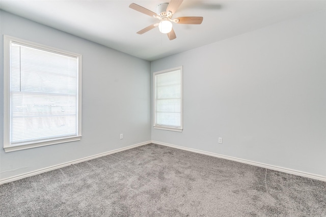 carpeted empty room featuring a ceiling fan and baseboards
