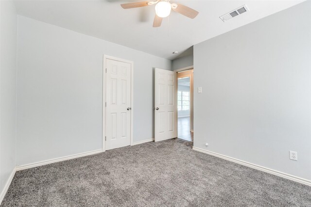 unfurnished bedroom with baseboards, a ceiling fan, visible vents, and carpet floors
