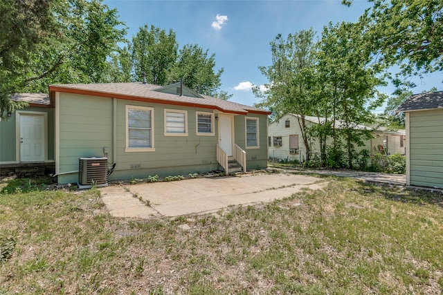 rear view of property with a lawn, central air condition unit, a patio, and entry steps