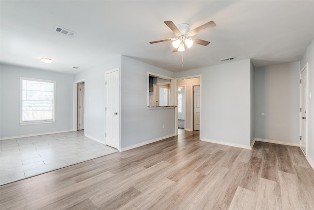 unfurnished living room featuring light wood-type flooring, baseboards, a ceiling fan, and visible vents