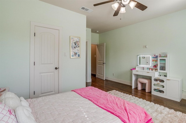 bedroom featuring baseboards, wood finished floors, visible vents, and ceiling fan