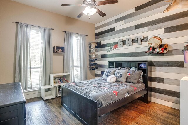 bedroom with baseboards, multiple windows, and wood finished floors