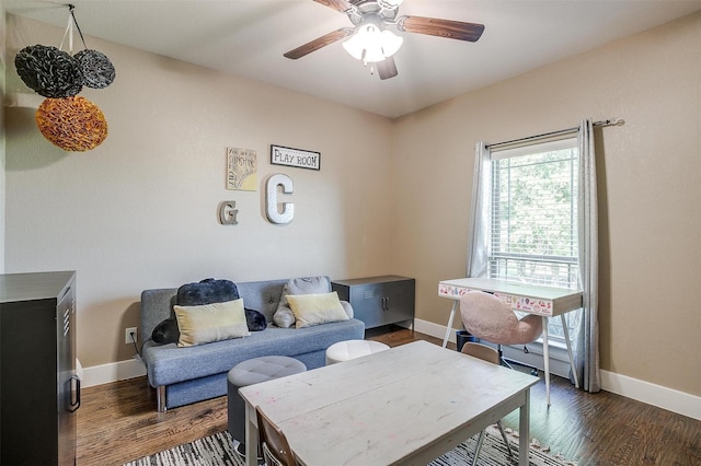 living area featuring ceiling fan, baseboards, and dark wood-style flooring