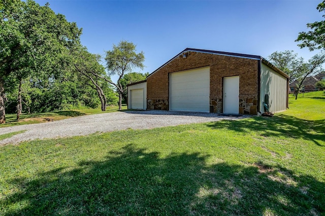exterior space with a yard, a detached garage, an outbuilding, and stone siding