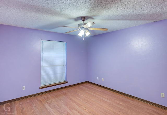 spare room featuring a ceiling fan, baseboards, a textured ceiling, and light wood-style flooring