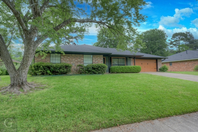 ranch-style home with concrete driveway, brick siding, a front yard, and a garage