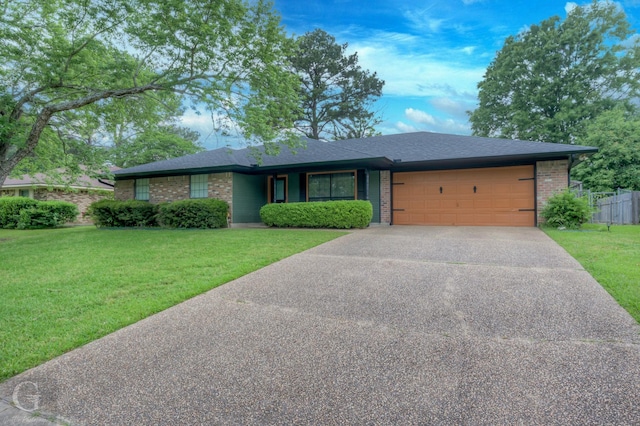 single story home with brick siding, an attached garage, and driveway