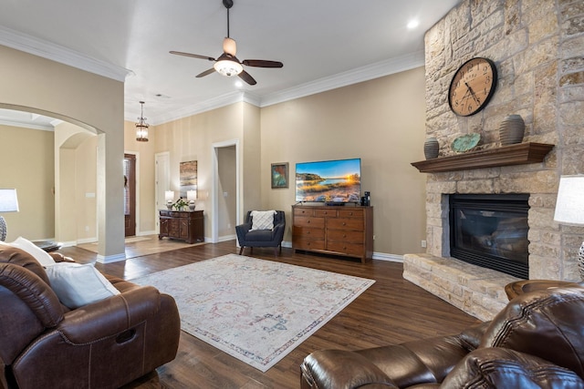 1027 Addison Ave, Pottsboro, TX 75076 - living room featuring a ceiling fan, arched walkways, ornamental molding, a stone fireplace, and dark wood-style flooring