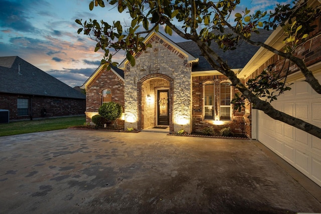 1027 Addison Ave, Pottsboro, TX 75076 - french country style house with brick siding, cooling unit, stone siding, a shingled roof, and driveway
