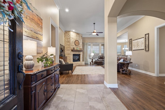 1027 Addison Ave, Pottsboro, TX 75076 - entryway with a stone fireplace, ornamental molding, ceiling fan, arched walkways, and baseboards