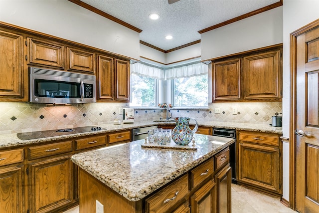 kitchen with ornamental molding, a kitchen island, a textured ceiling, light stone counters, and appliances with stainless steel finishes