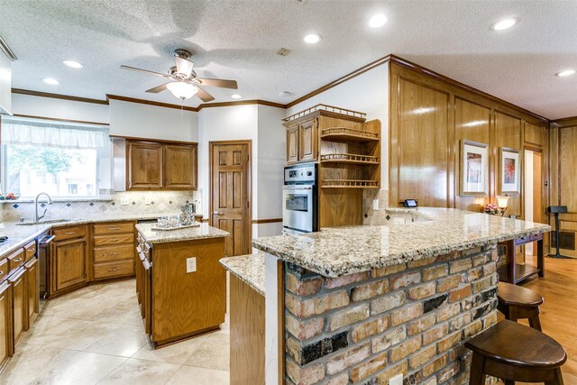 kitchen featuring ceiling fan, open shelves, a sink, a peninsula, and stainless steel oven