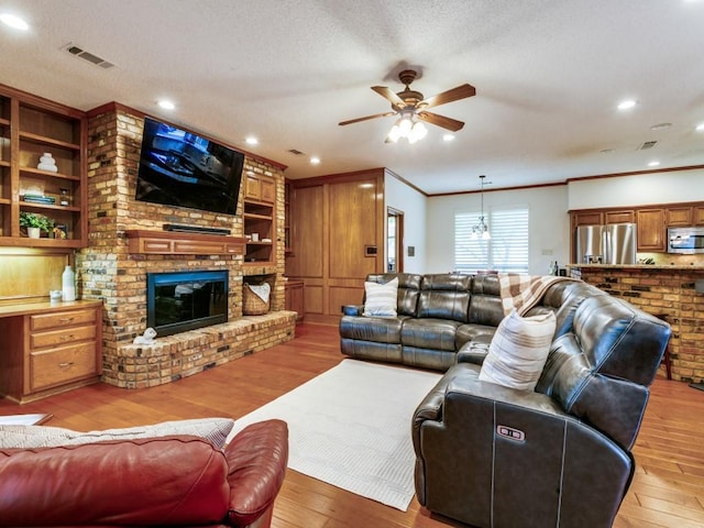 living area featuring crown molding, a ceiling fan, and light wood-style flooring