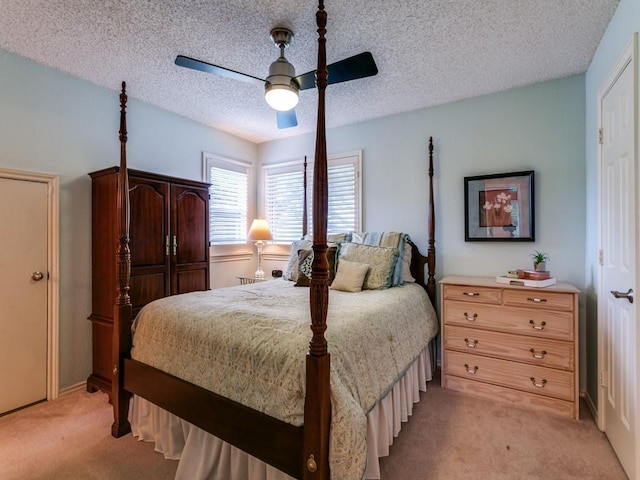 bedroom featuring ceiling fan, light carpet, and a textured ceiling