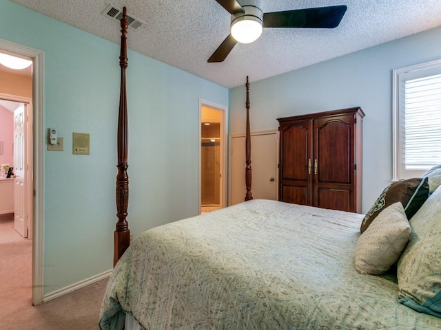 bedroom with ceiling fan, a textured ceiling, visible vents, carpet floors, and connected bathroom