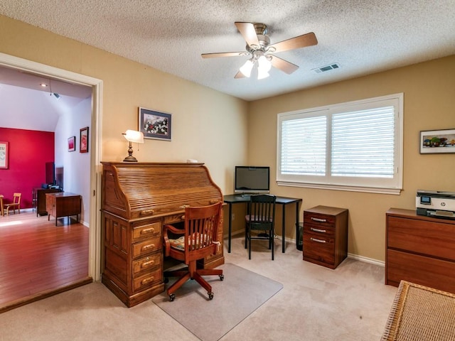 home office with light colored carpet, ceiling fan, visible vents, and baseboards