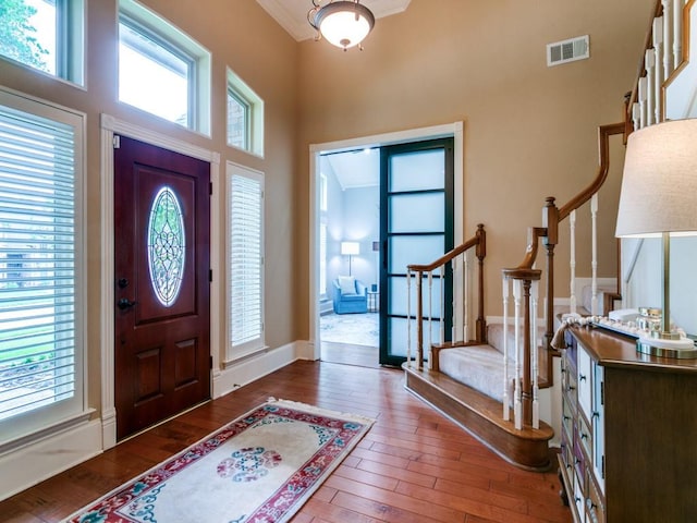 entrance foyer with wood-type flooring, visible vents, plenty of natural light, and stairway