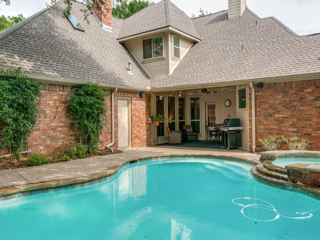 view of swimming pool with a patio, ceiling fan, a pool with connected hot tub, and grilling area