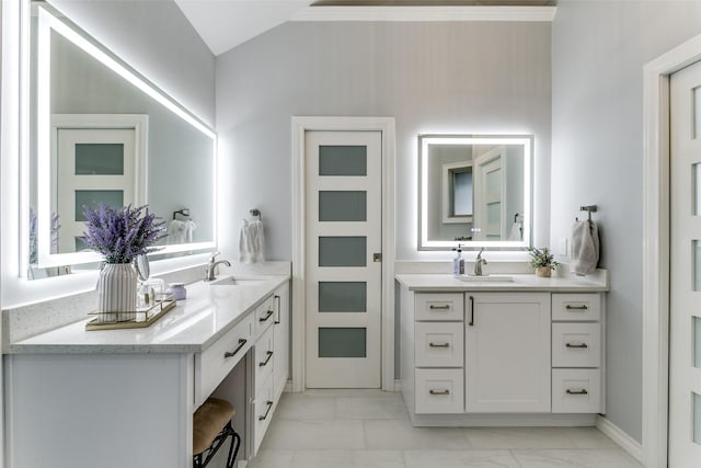 bathroom with two vanities, a sink, and marble finish floor
