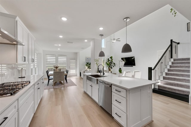 kitchen with a sink, recessed lighting, light wood-style floors, light countertops, and appliances with stainless steel finishes