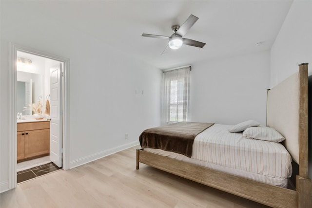 bedroom with wood finished floors, a sink, ensuite bath, baseboards, and ceiling fan