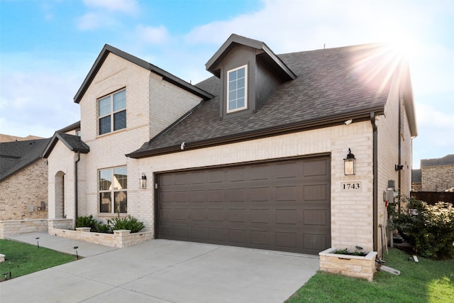 view of front facade with brick siding, an attached garage, driveway, and roof with shingles