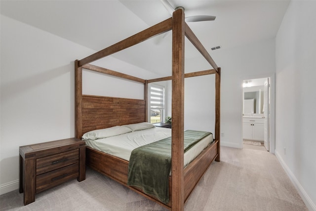 bedroom with vaulted ceiling, visible vents, a ceiling fan, connected bathroom, and light colored carpet