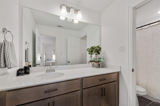 ensuite bathroom with toilet, tile patterned floors, vanity, ensuite bath, and visible vents