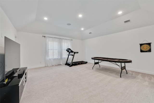 workout area featuring lofted ceiling, light carpet, and visible vents