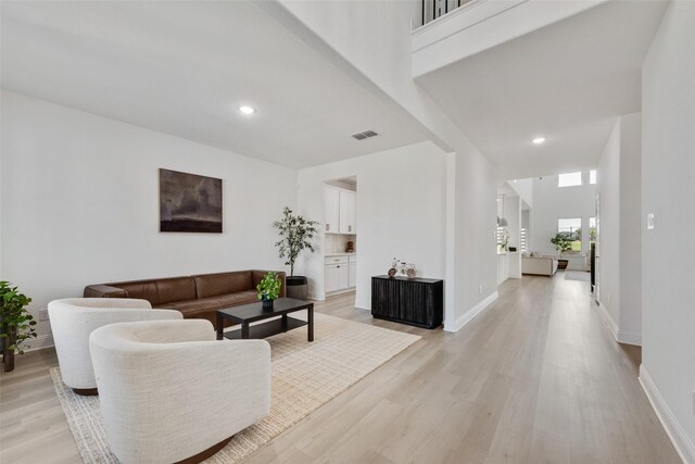 living area featuring recessed lighting, light wood-style flooring, visible vents, and baseboards