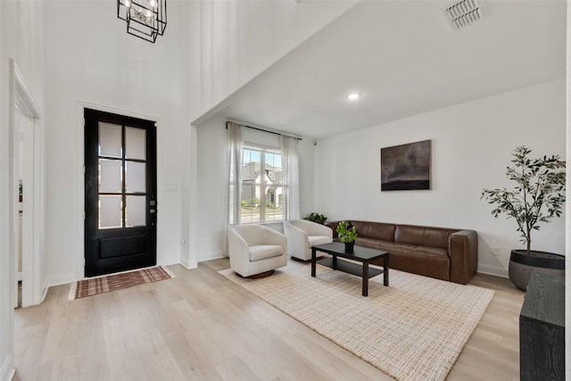 foyer featuring baseboards, wood finished floors, visible vents, and recessed lighting