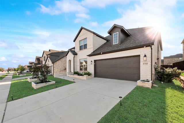 view of front of house with a shingled roof, driveway, brick siding, and a front lawn