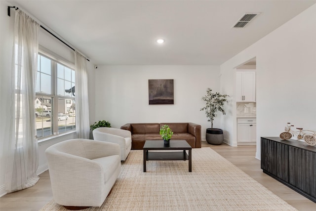 living area featuring recessed lighting, visible vents, light wood finished floors, and baseboards