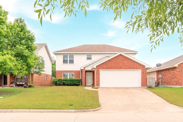 traditional home with brick siding, a garage, a front lawn, and driveway