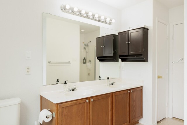 bathroom featuring a sink, walk in shower, toilet, and double vanity