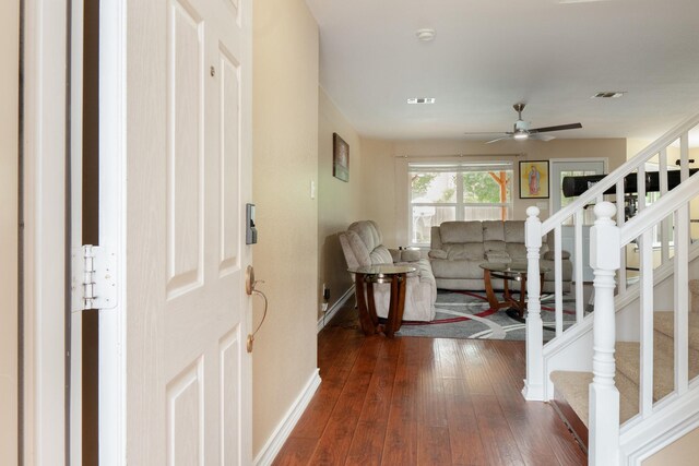entryway with a ceiling fan, visible vents, stairway, baseboards, and dark wood-style floors