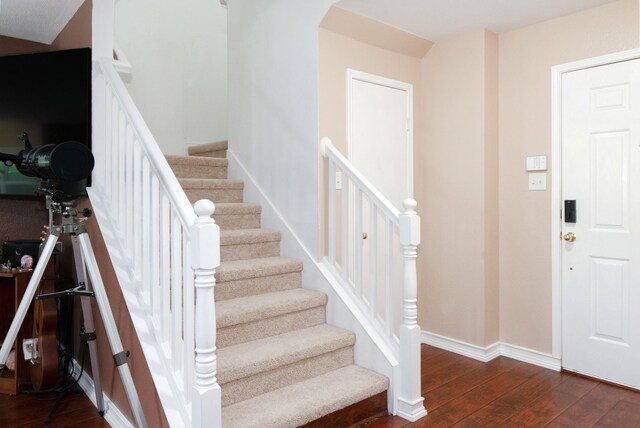 stairway with baseboards and hardwood / wood-style floors