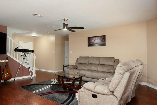 living area featuring wood-type flooring, stairs, a ceiling fan, baseboards, and visible vents