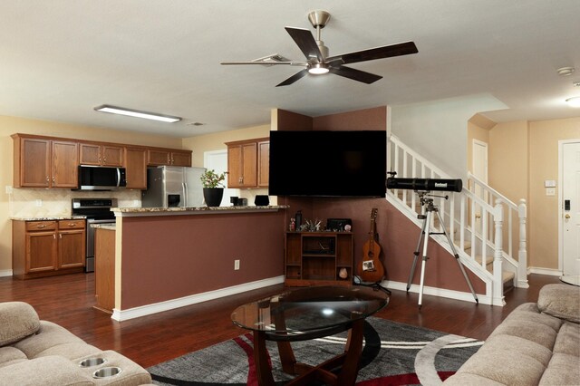 living room featuring ceiling fan, dark wood finished floors, baseboards, and stairway