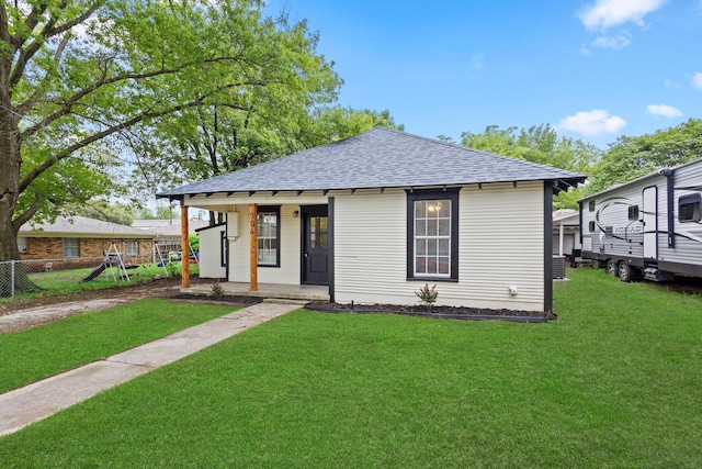 bungalow-style house with roof with shingles, fence, a porch, and a front yard