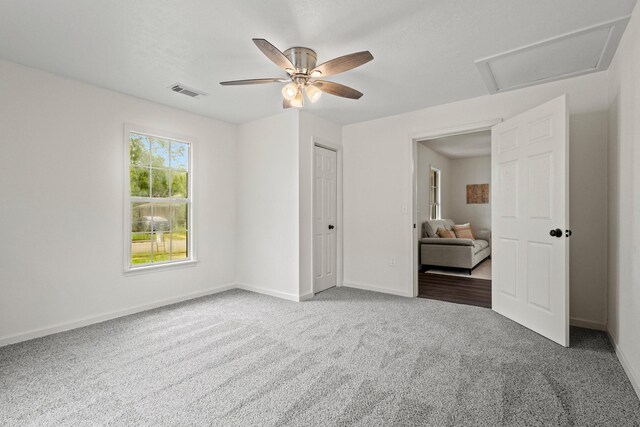 unfurnished bedroom featuring attic access, baseboards, visible vents, and carpet